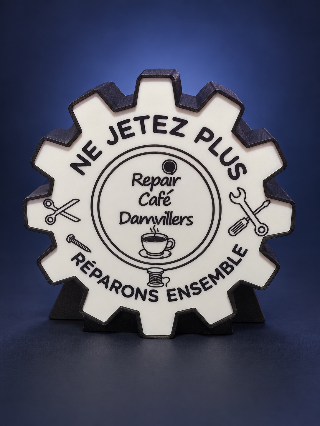 Logo du Repair Café Damvillers imprimé en relief, en forme de roue dentée