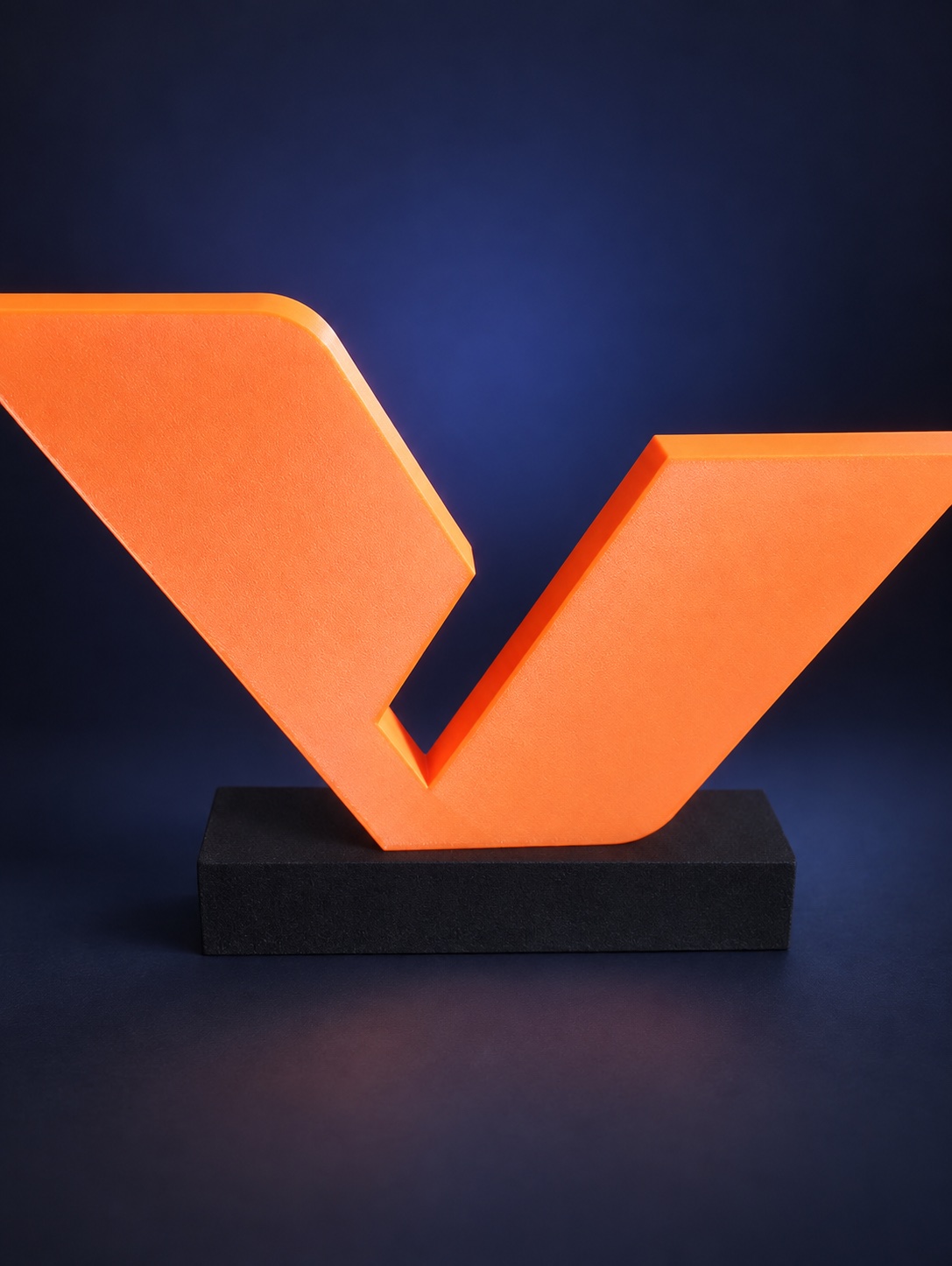 Trophée Flo3D en forme de V orange sur un socle sombre